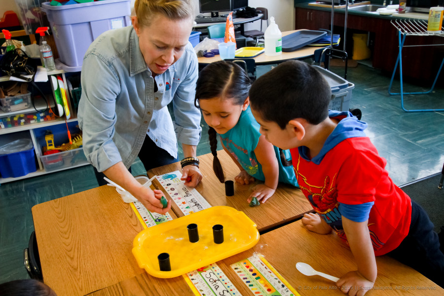 Staff member demonstrating project to 2 children